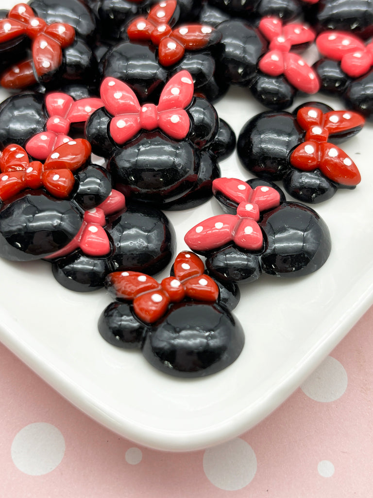 a white plate topped with black and red minnie mouse candies