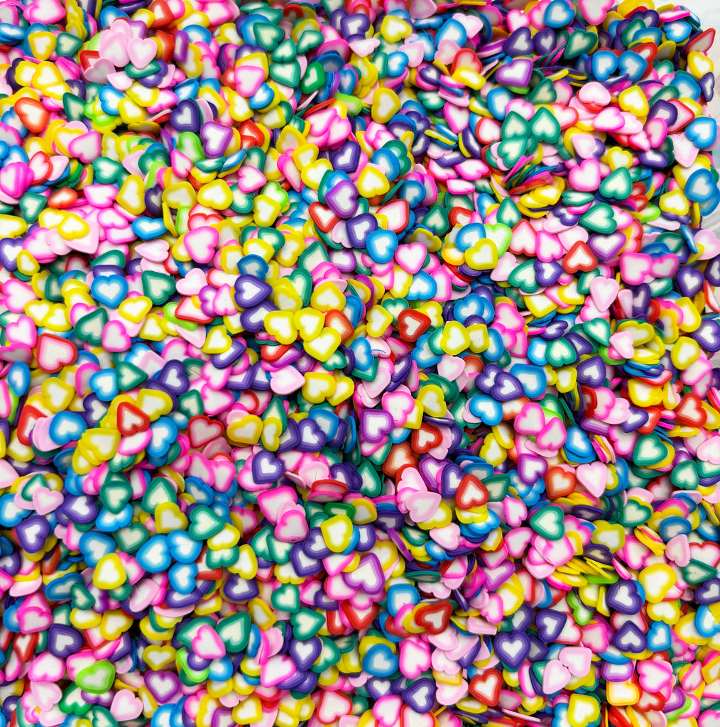 a pile of multicolored hearts on a white surface
