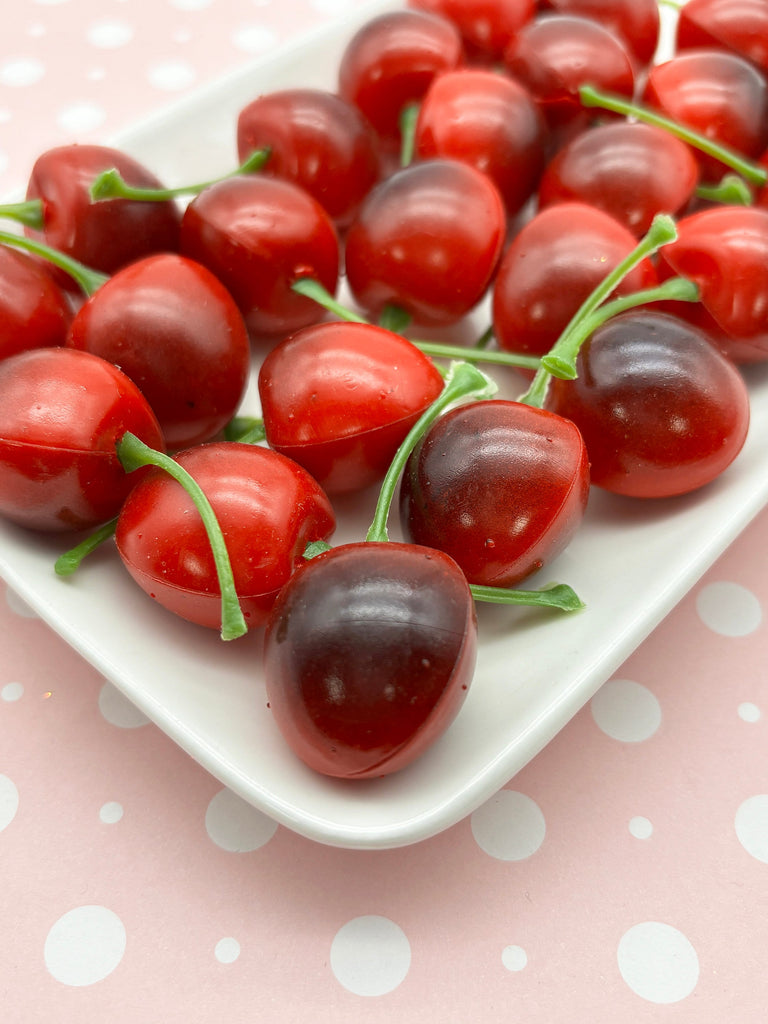 a white plate topped with lots of red cherries