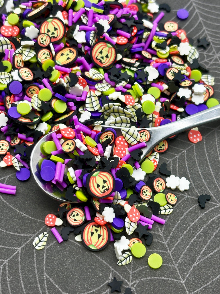 a spoon full of halloween sprinkles on a table