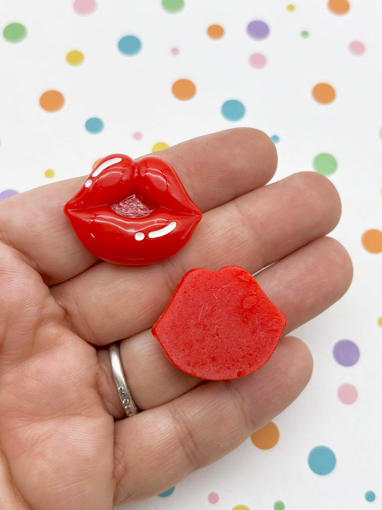 A hand holding two red heart-shaped objects against a background with colorful polka dots.