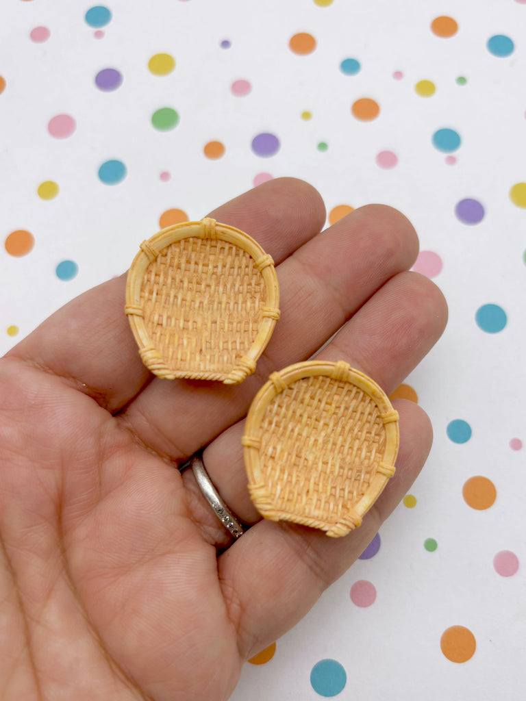 A hand holding two small, woven baskets against a background with colorful polka dots.