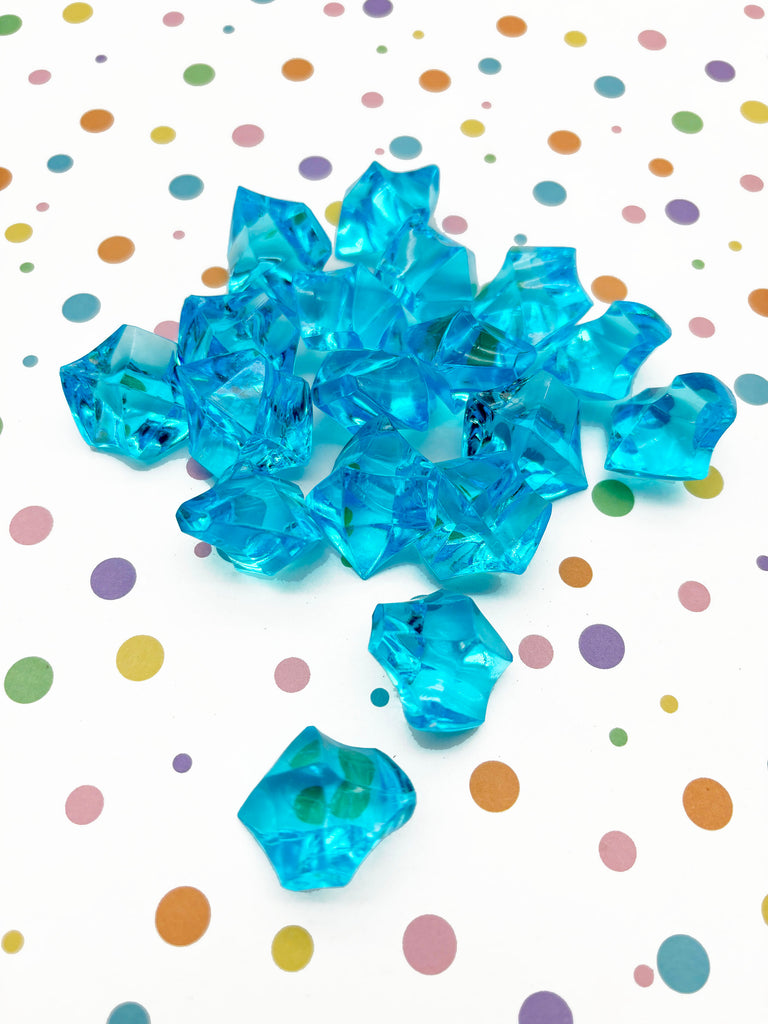 a pile of blue glass beads on a polka dot tablecloth