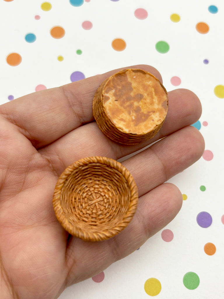 A hand holding a small woven basket and a small round object against a background with colorful polka dots.