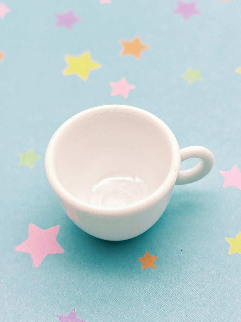 a small white cup sitting on top of a table