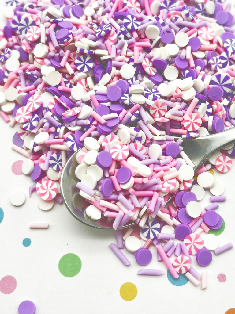 a spoon full of candy sprinkles on a table