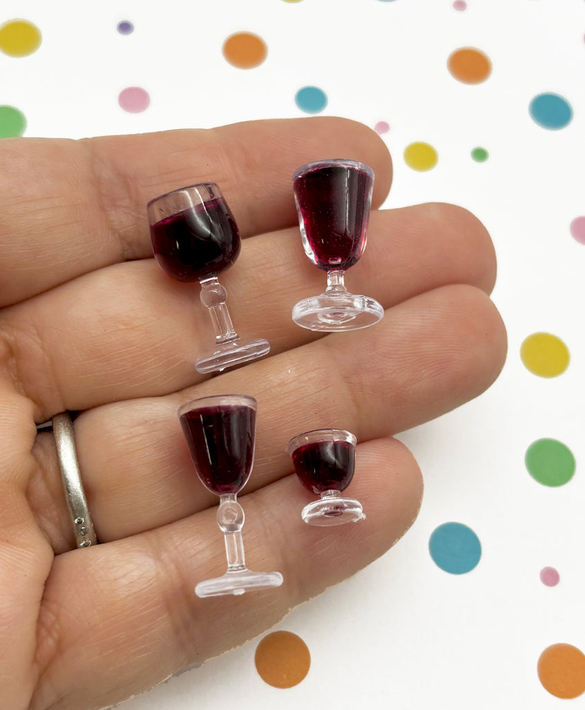 a person holding three wine glasses in their hand