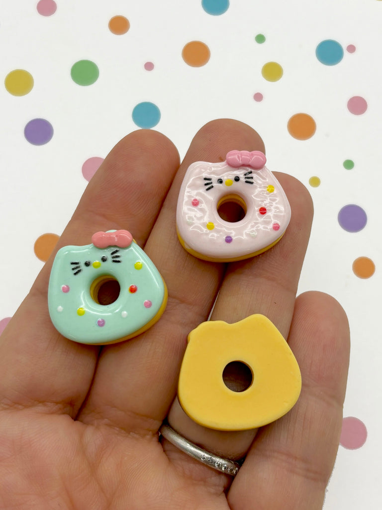 a person is holding two miniature donuts in their hand