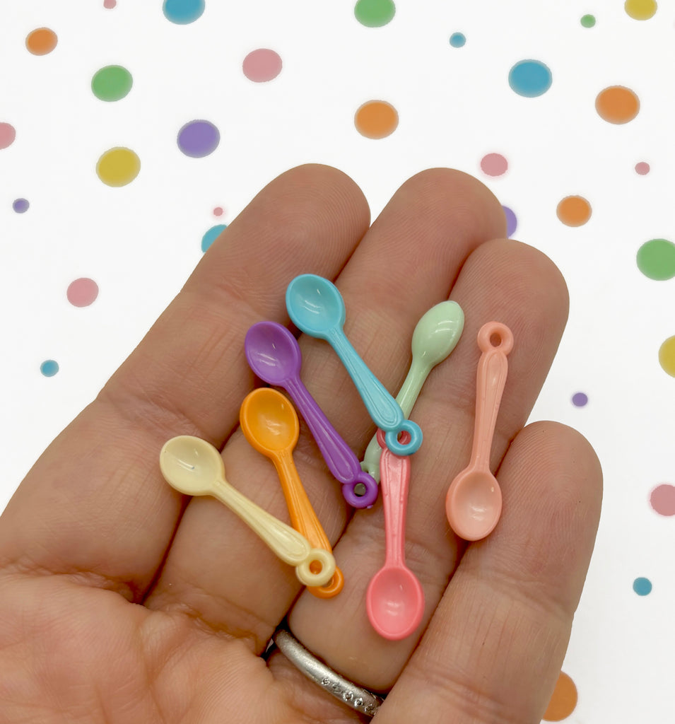 a person is holding five small spoons in their hand