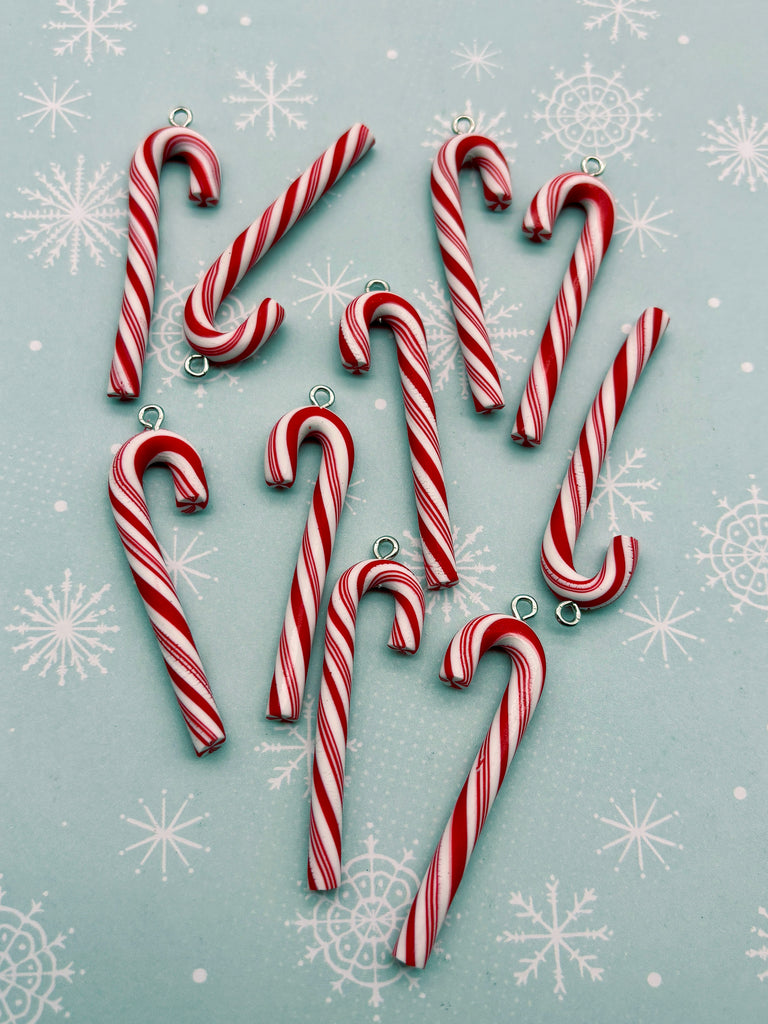 a collection of red and white striped candy canes arranged on a light blue background with white snowflakes.