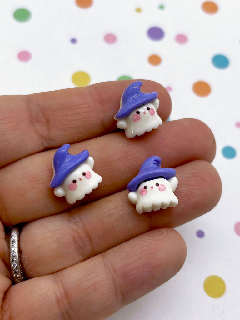 a hand holding three tiny white and blue gnomes