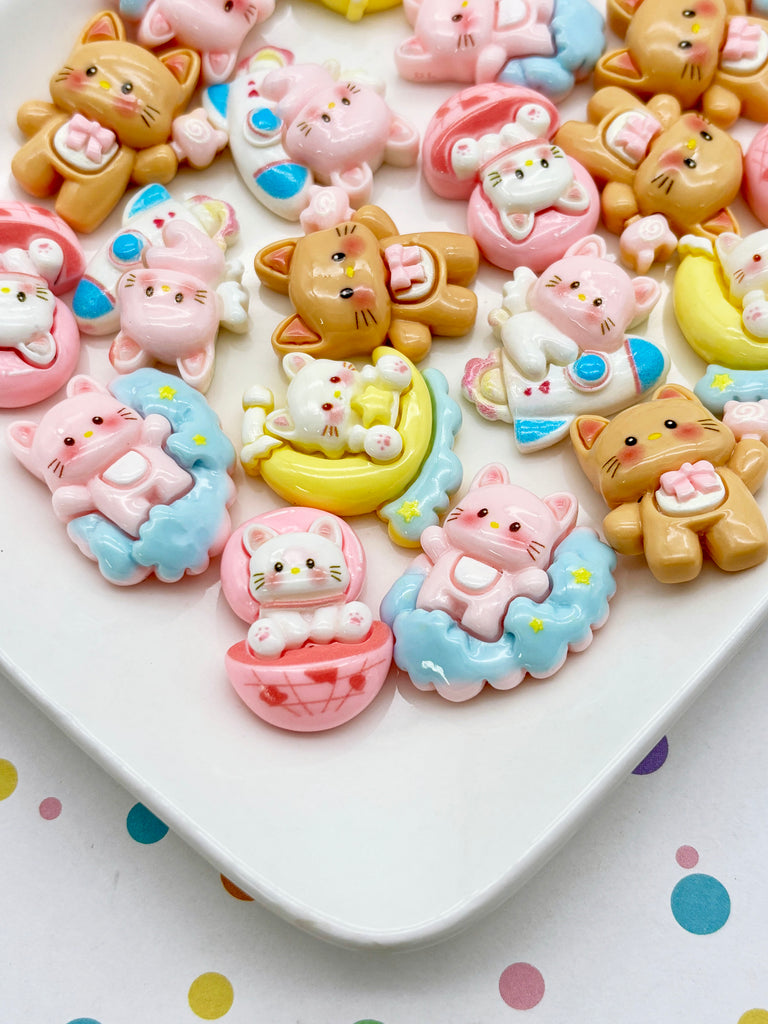 a collection of colorful, whimsical cat-themed trinkets arranged on a white surface.