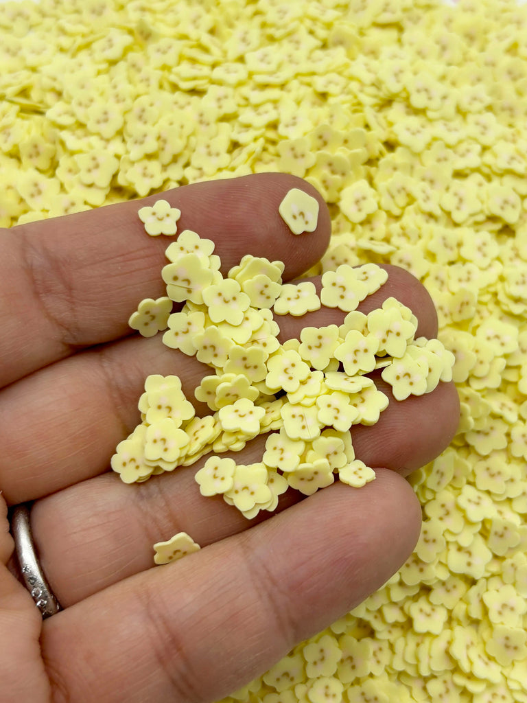 a hand holding a handful of tiny yellow flowers