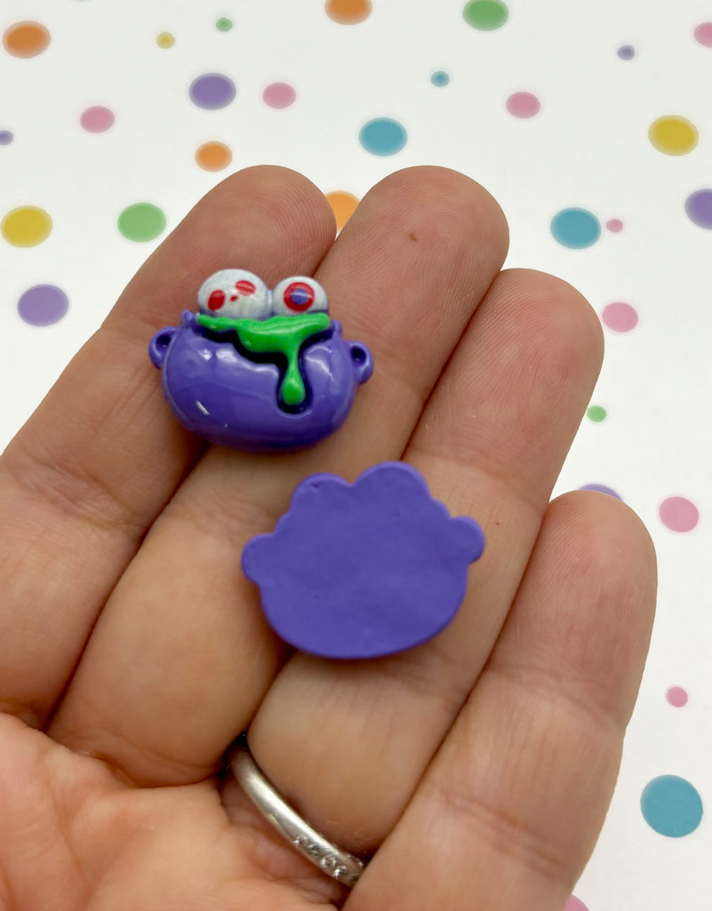 a hand holding a purple toy with a frog on it