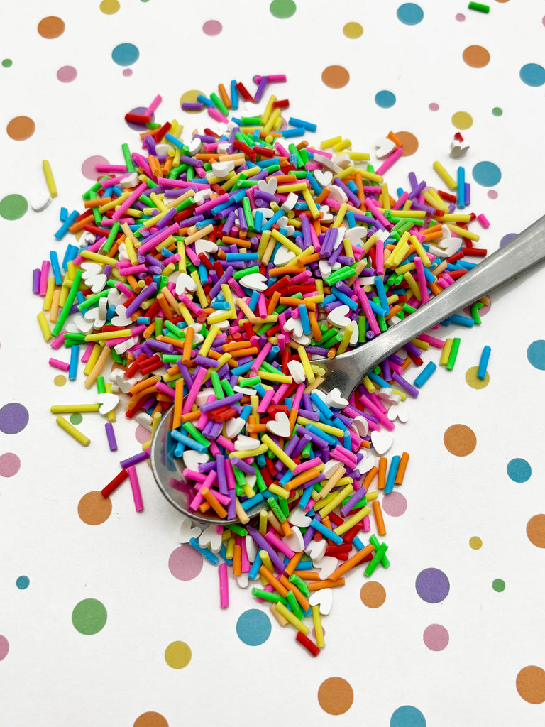 a spoon filled with sprinkles on top of a table