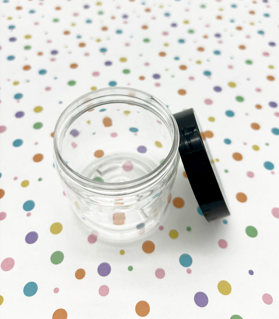 a small glass jar with a black lid