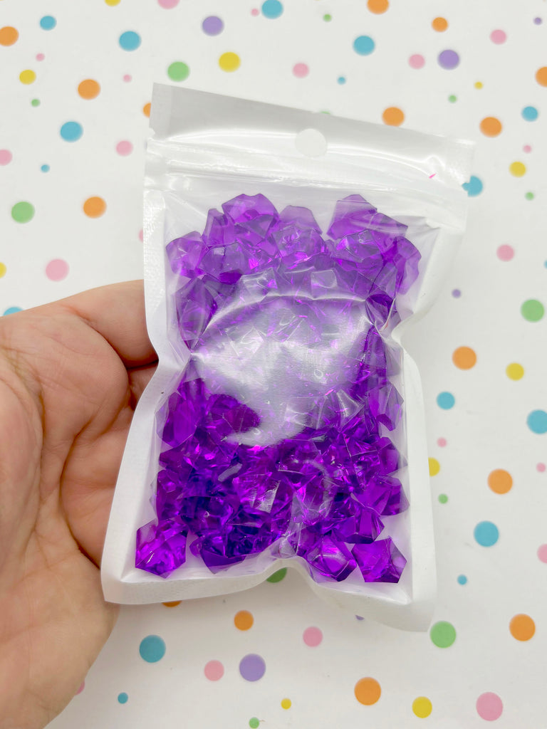 a hand holding a bag of purple and white confetti