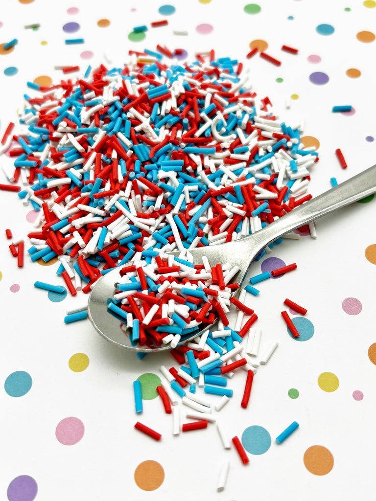 a spoon full of red, white and blue sprinkles