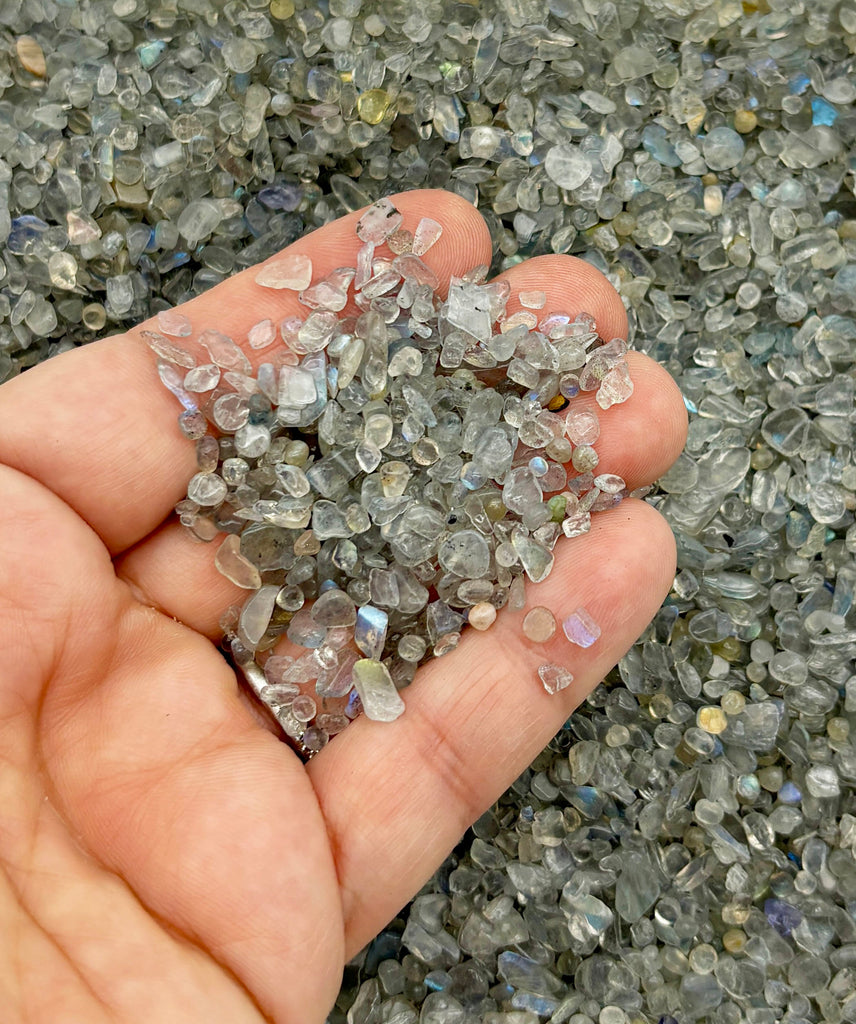 a person holding a handful of small rocks in their hand