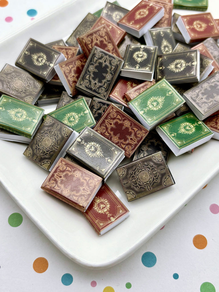 a collection of small, colorful books or miniature books arranged on a white plate or tray.