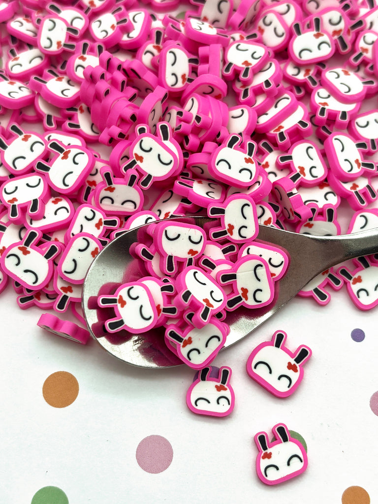 a spoon full of pink and white buttons