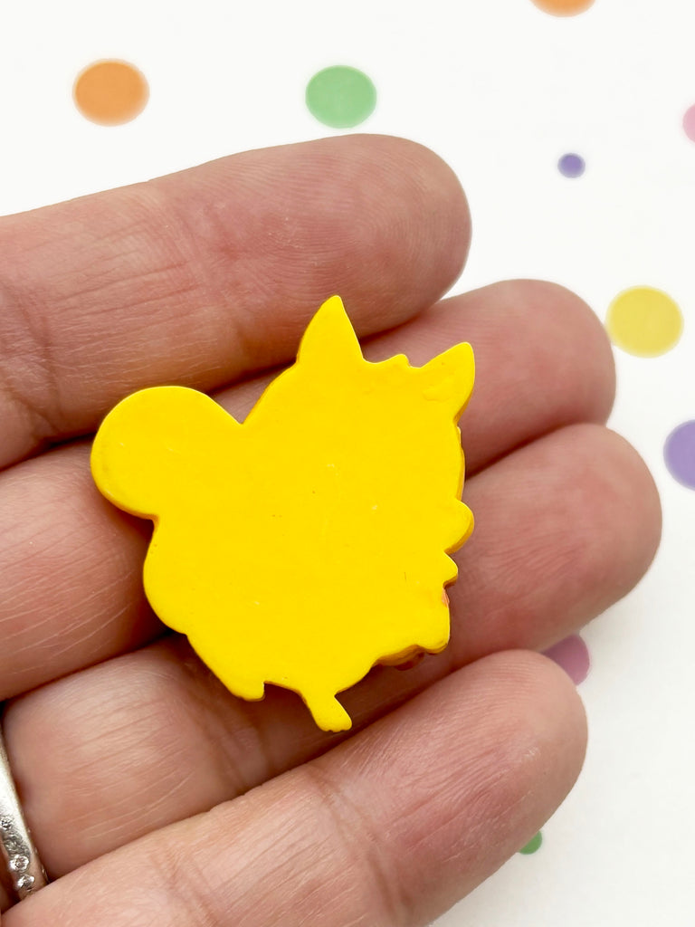 A hand holding a yellow object, which appears to be a small, round, yellow shape.