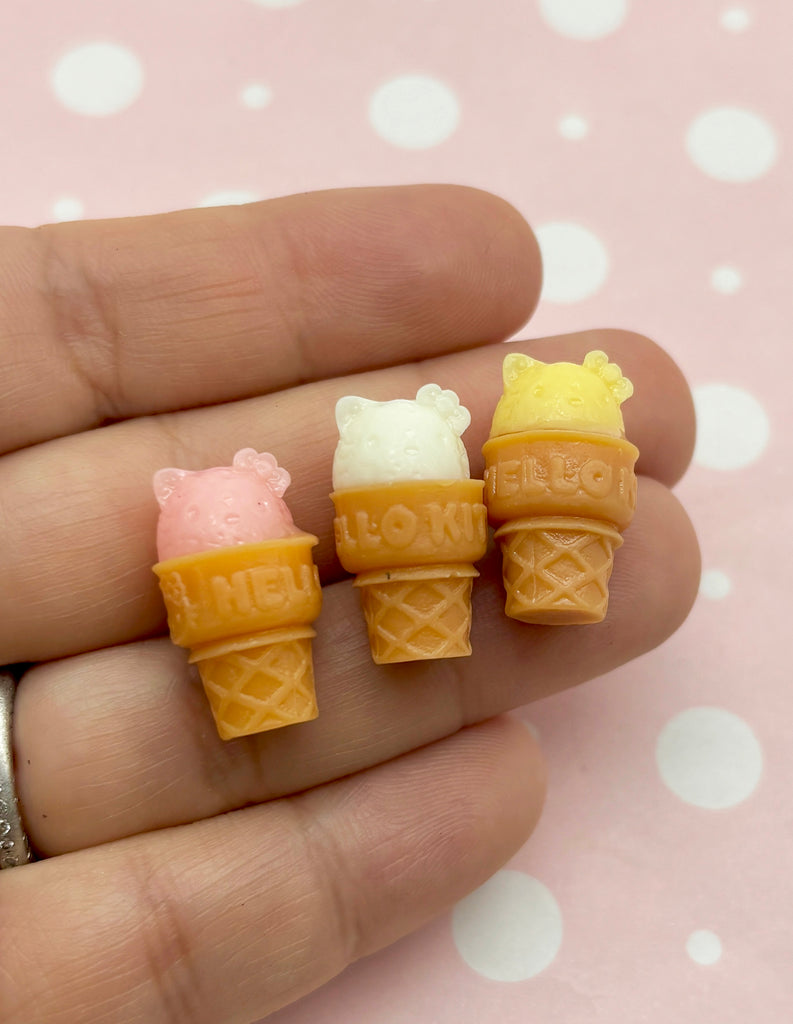 three miniature ice cream cones are in a hand