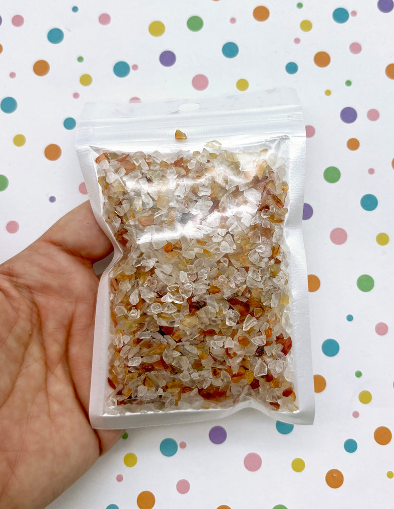 a hand holding a bag of granola in front of a polka dot background