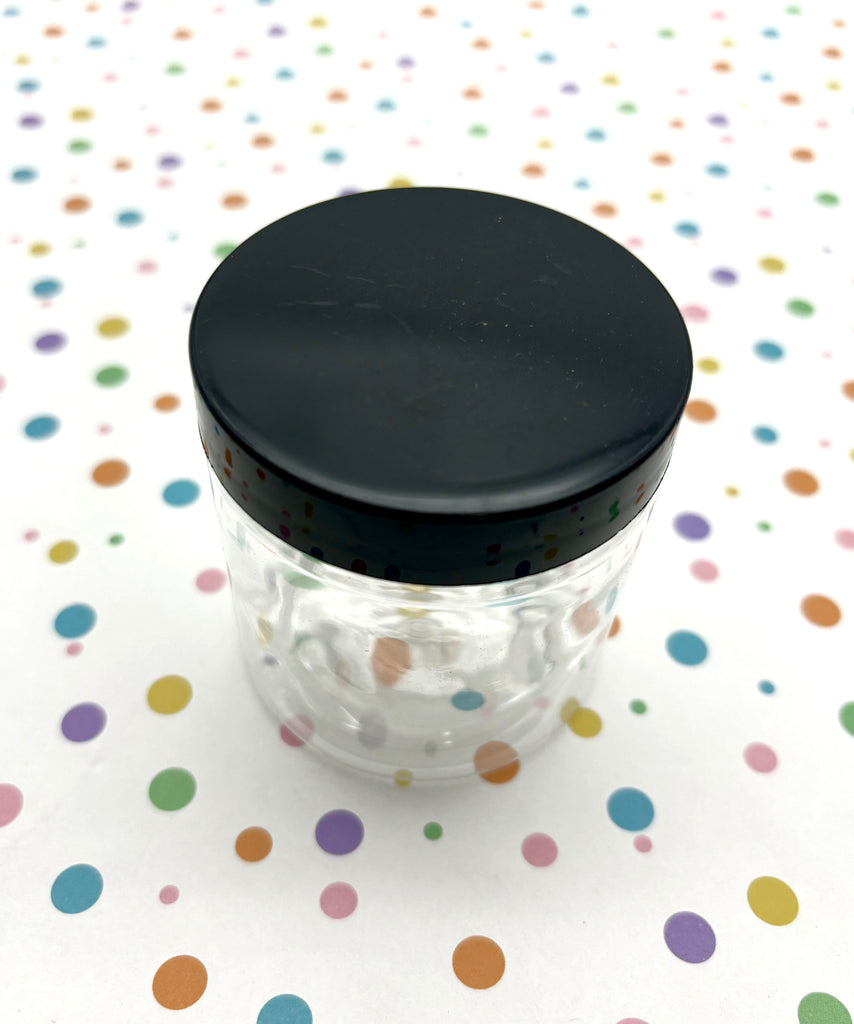 a small jar with a black lid on a polka dot tablecloth