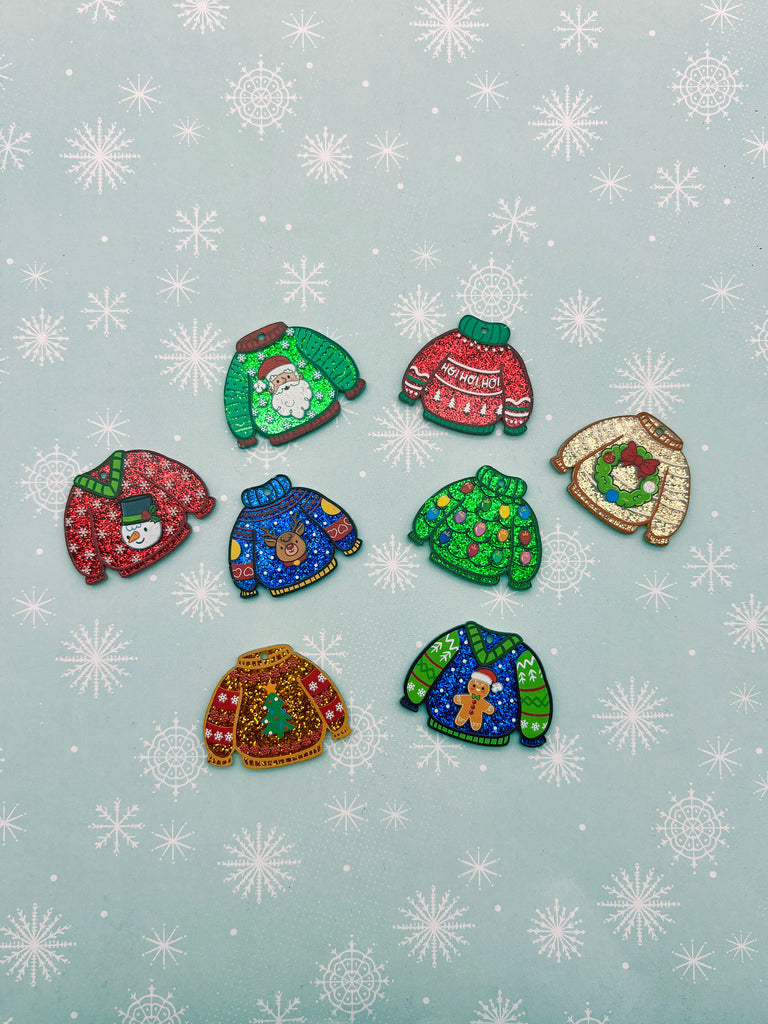 a collection of colorful, patterned, and festive Christmas sweaters arranged on a snowy background.