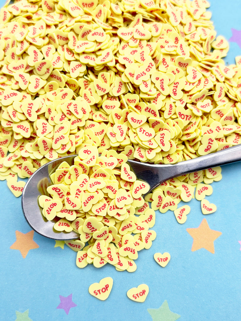 a spoon full of conversation hearts on a blue background