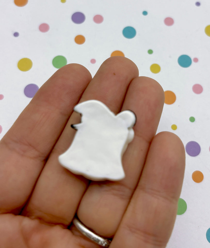 a hand holding a small white bear brooch