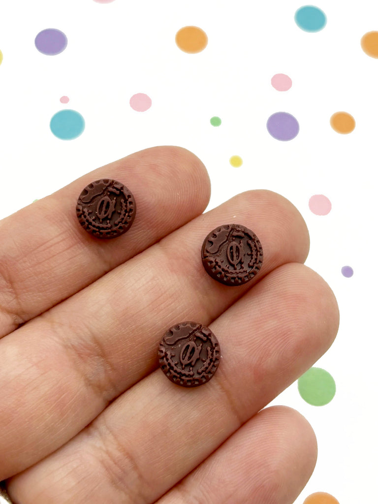 a person is holding two chocolate buttons in their hand