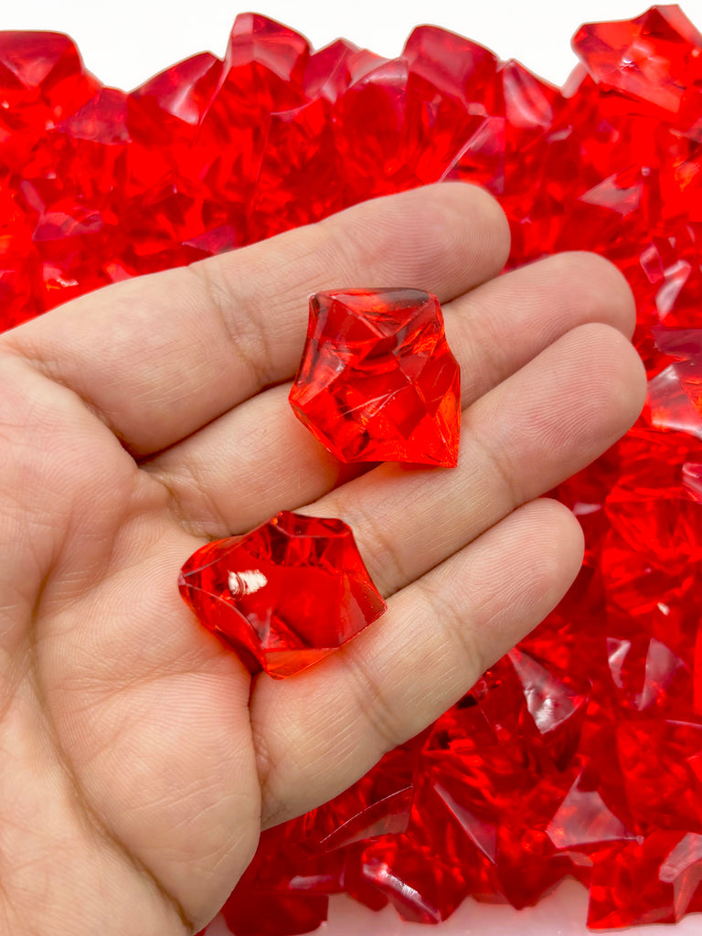 a hand holding a red piece of glass in it's palm