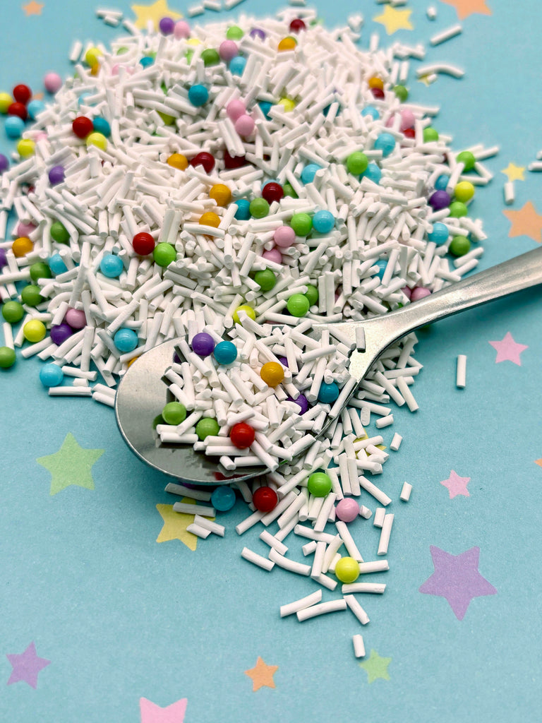 a spoon full of sprinkles on a blue surface