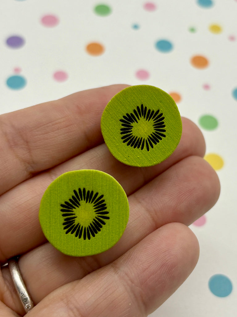 a person holding a pair of green buttons in their hand