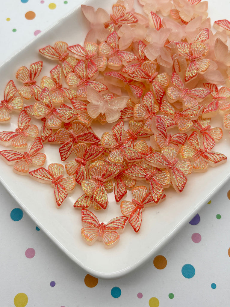 a white plate filled with numerous small, colorful, and glittery butterfly-shaped objects.