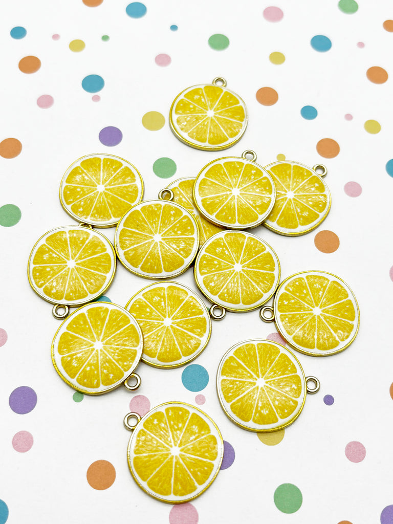a collection of yellow lemon-shaped charms or pendants, arranged on a white background with colorful polka dots.