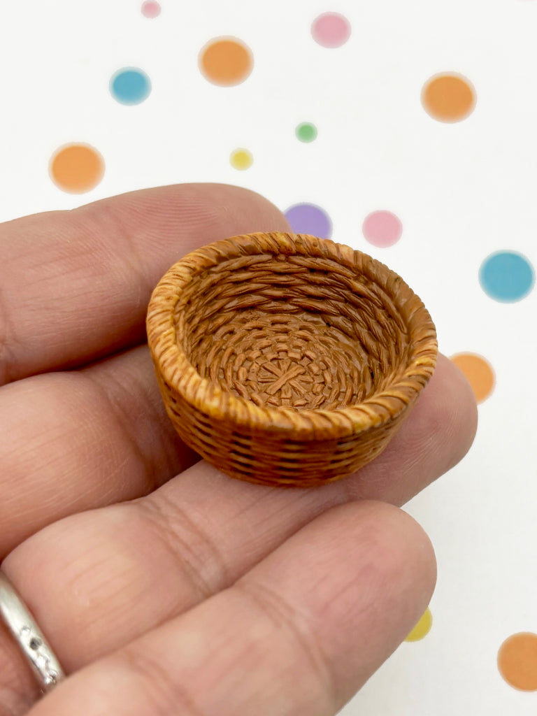 A hand holding a small woven basket against a background with colorful polka dots.