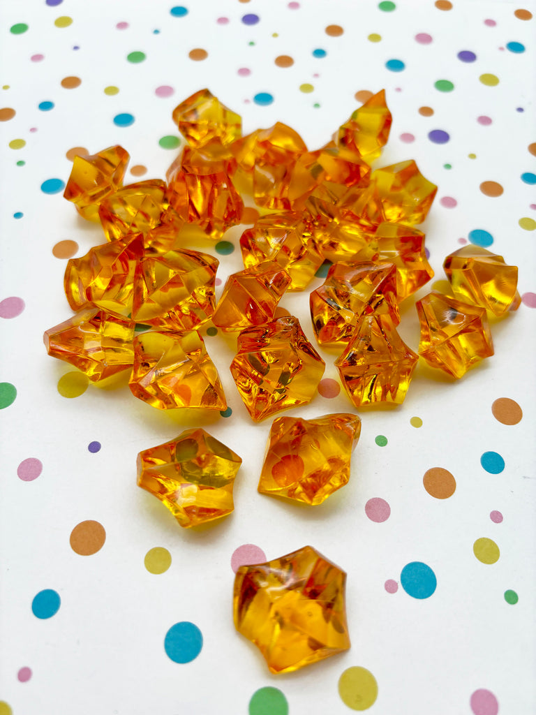 a pile of yellow crystal beads on a polka dot table
