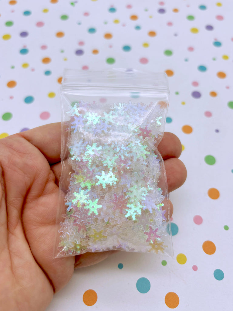 a hand holding a bag of white glitter