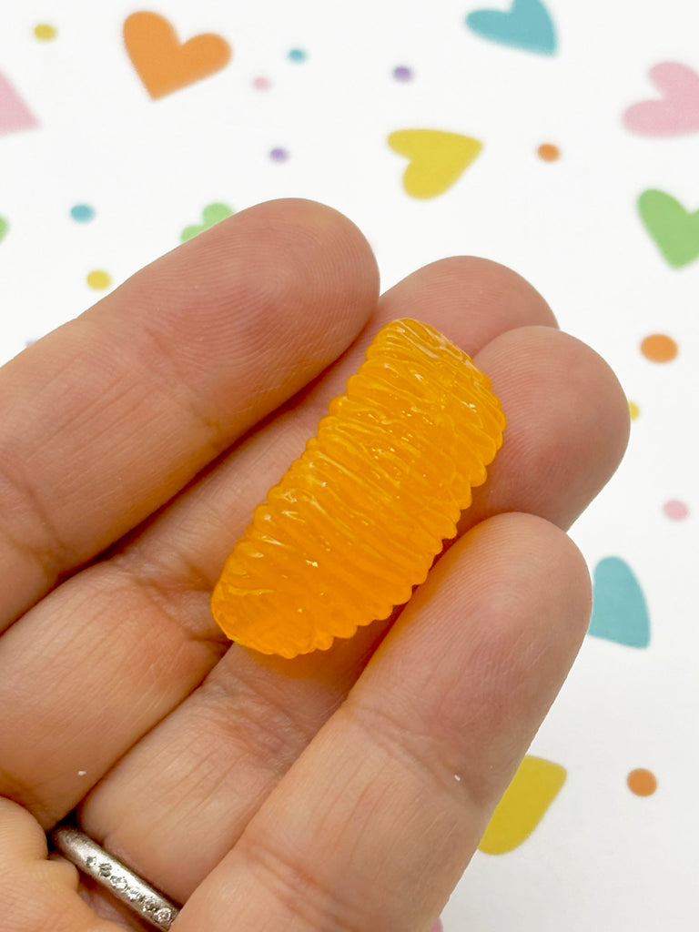 a person holding a small piece of fruit in their hand