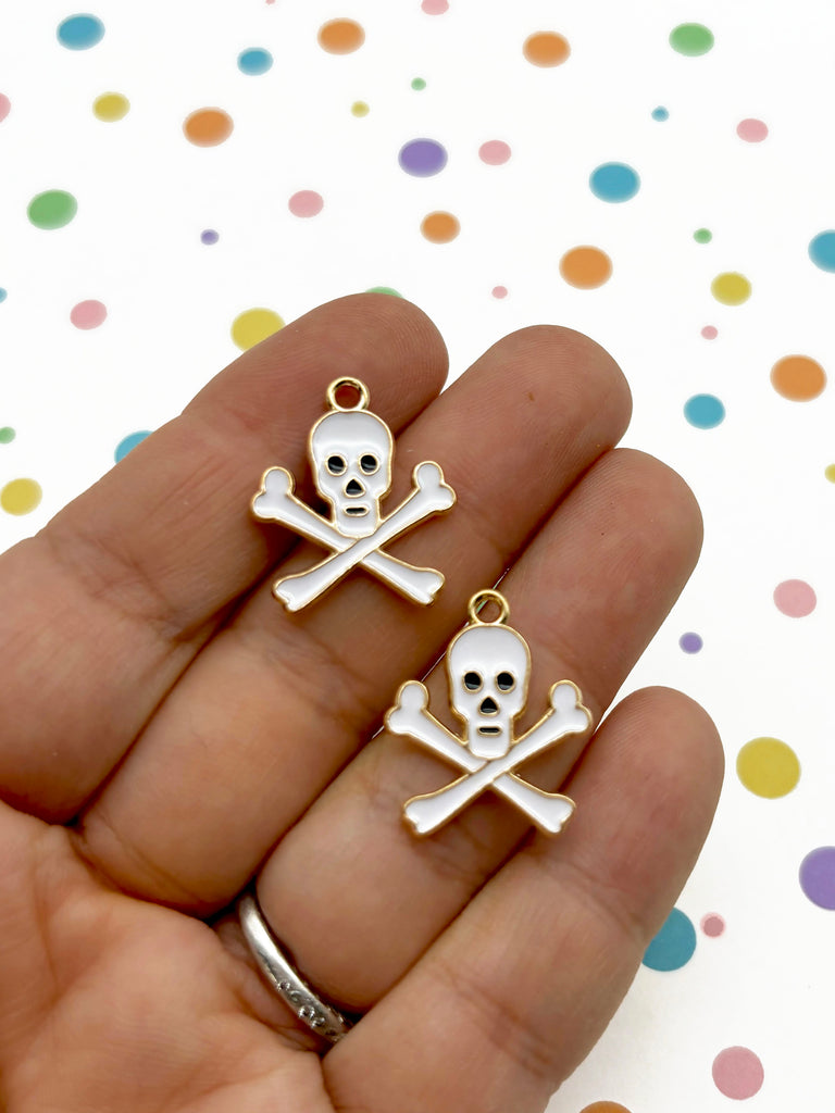 a pair of skull and crossbone earrings in gold