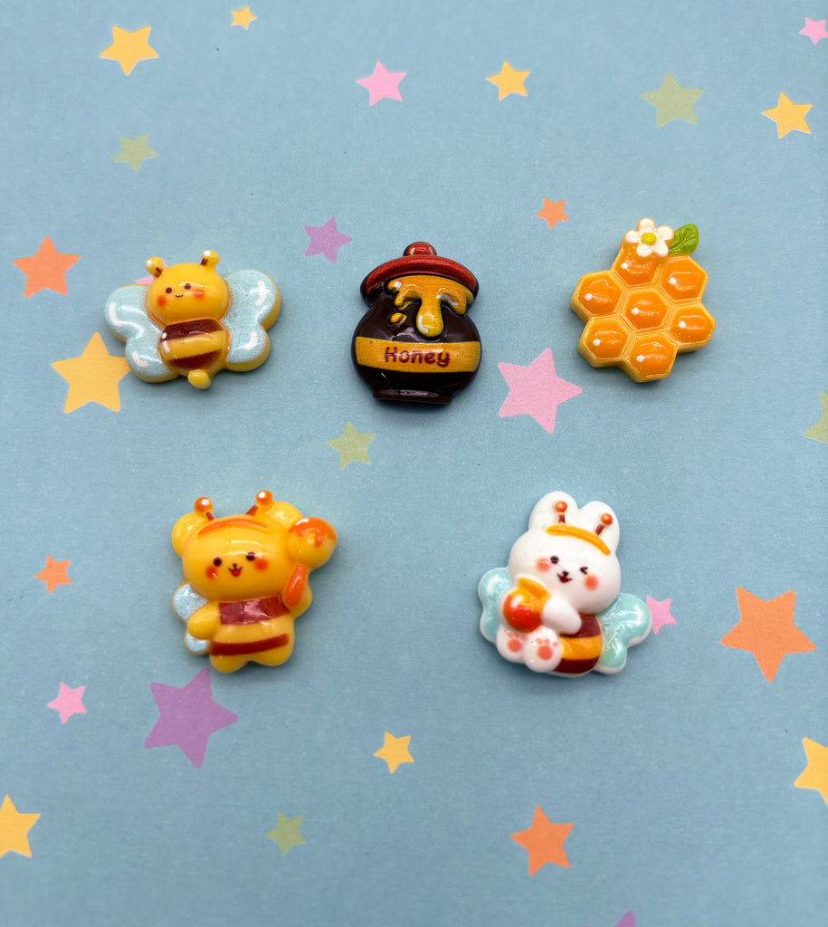 a set of four winnie the pooh pins sitting on top of a blue surface