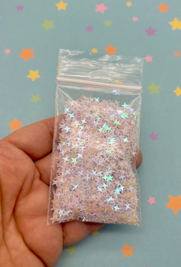 a hand holding a small bag of glitter