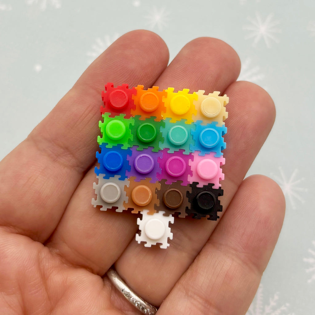 a hand holding a small multicolored piece of plastic