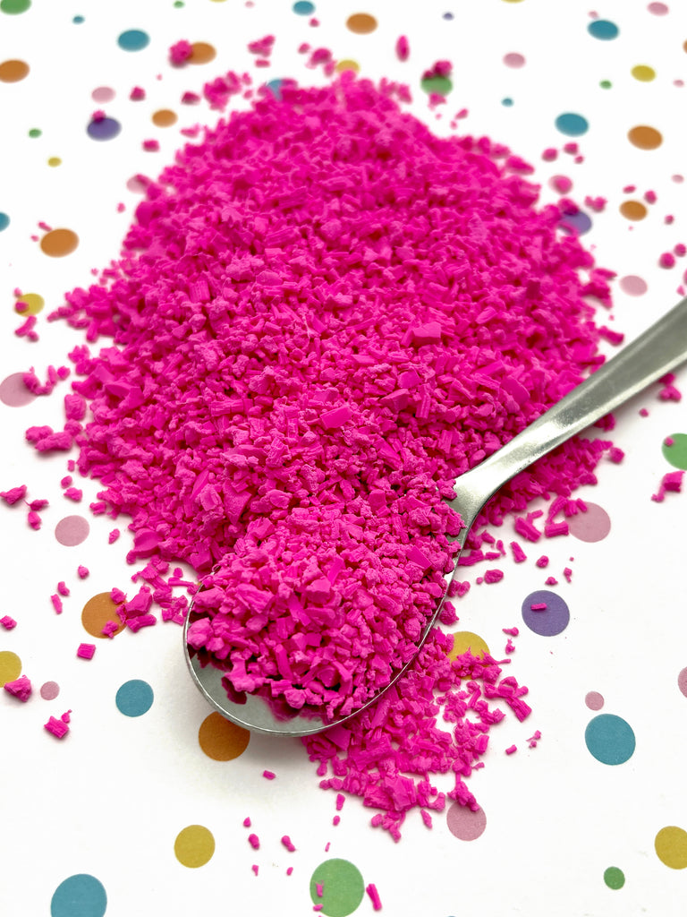 a spoon full of pink powder on a polka dot tablecloth