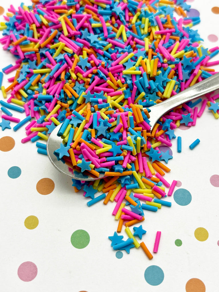 a spoon filled with sprinkles on top of a table