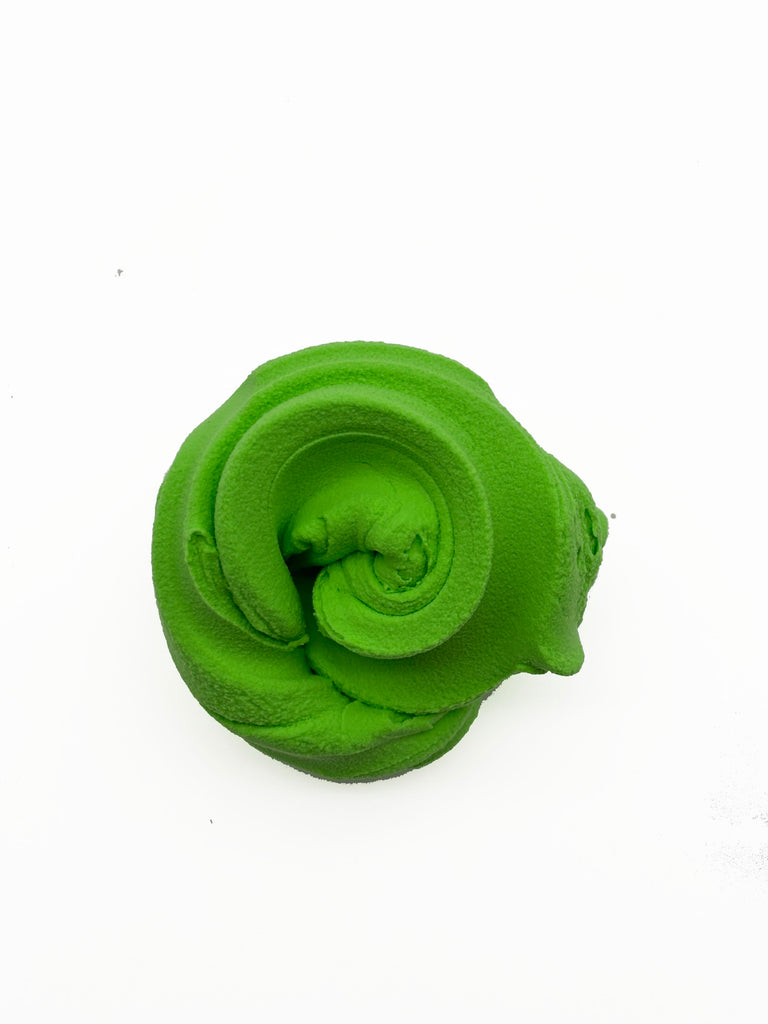 A single, bright green, twisted object resembling a piece of play dough or a similar soft, malleable material.