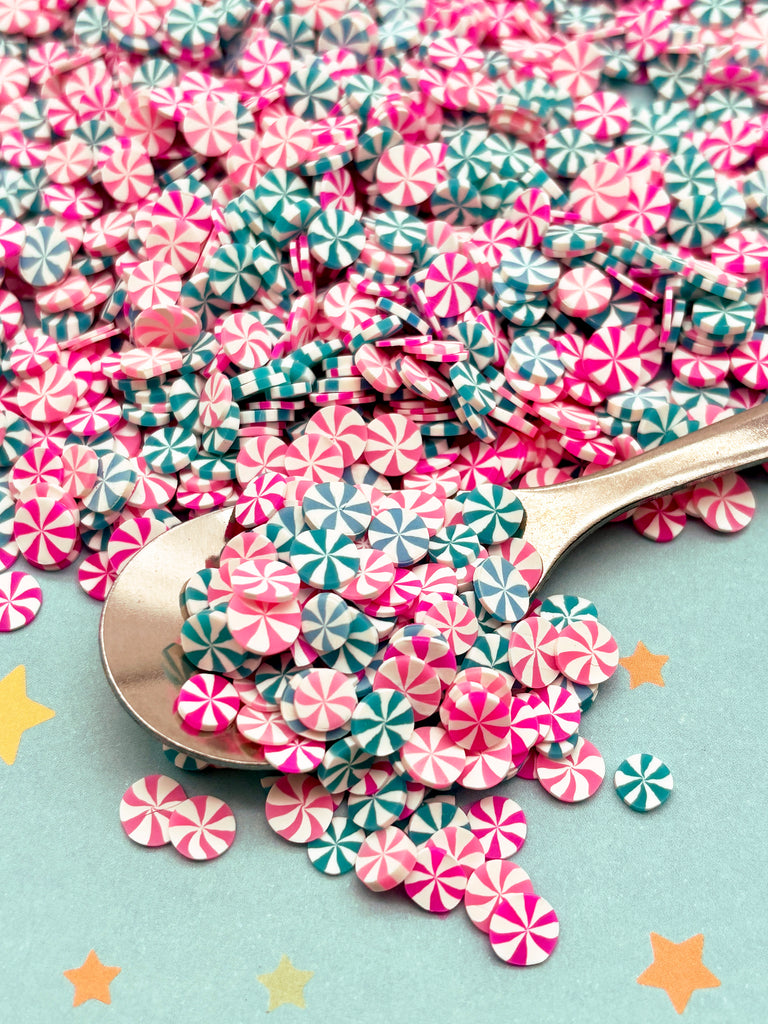 a spoon full of pink and blue candy canes